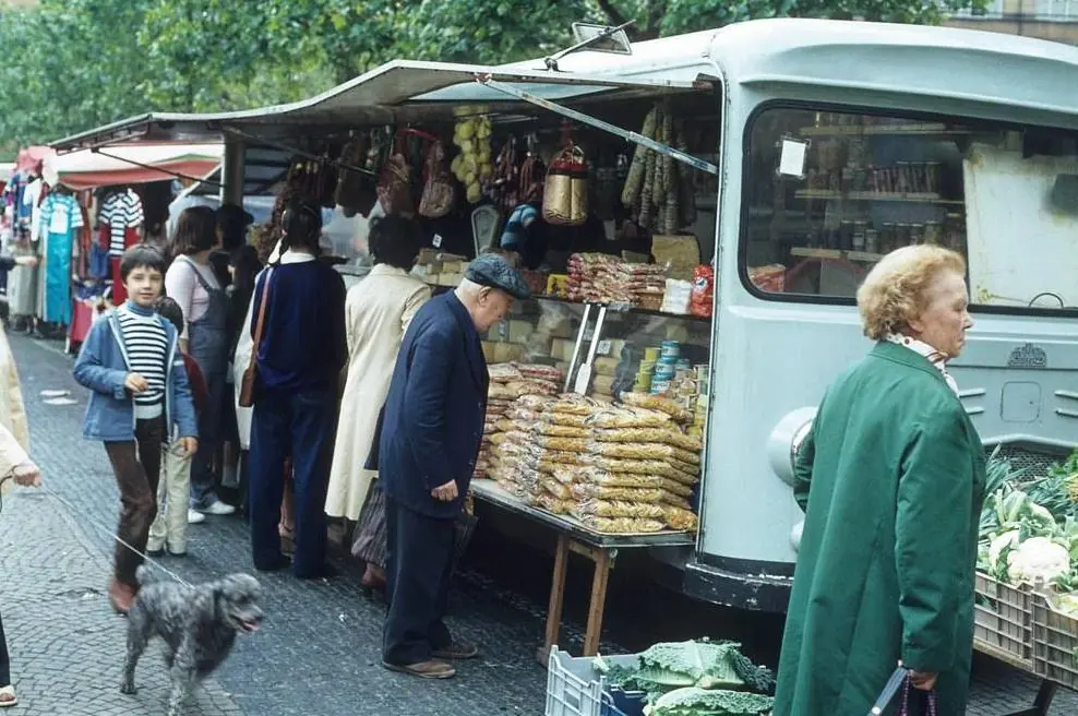 Un marché de plein air : des habitants font la queue devant l'étal d'une camionnette.